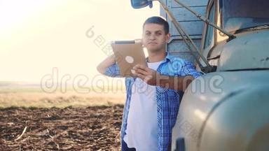 智慧农业。 生活方式男子农民司机站在卡车附近的数字平板电脑。 慢动作视频。 肖像